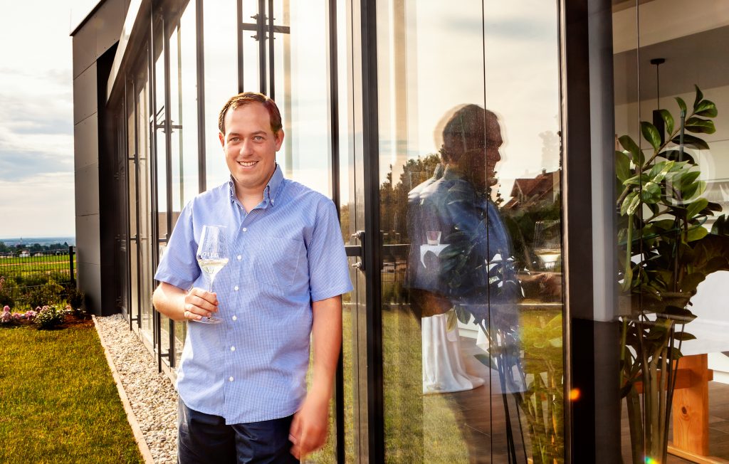 Stefan Gilg steht im Sonnenuntergang vor dem neuen Weinshop